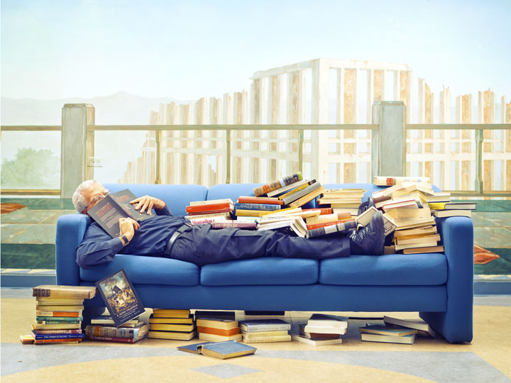 UCLA Professor lying down covered in books